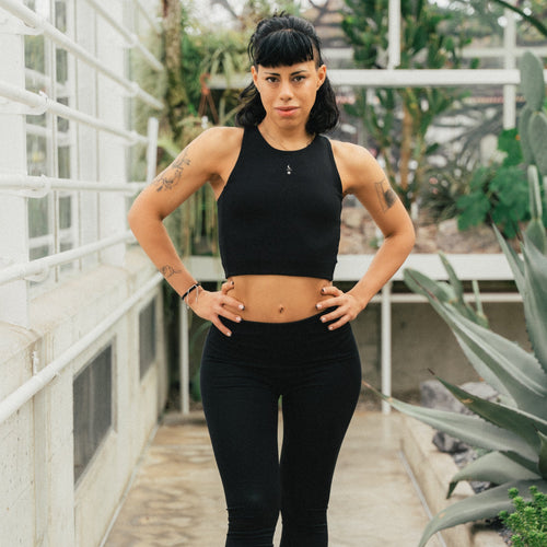 Pilates teacher wearing the black Ainé sustainable luxury sports top in natural TENCEL fabric