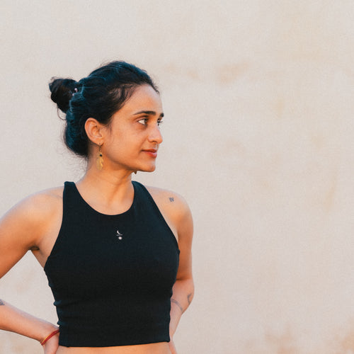 Moody portrait of pilates teacher wearing the Ainé sustainable activewear top made from Tencel